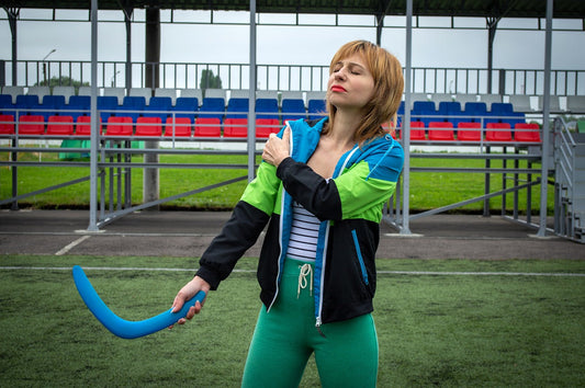 A woman in sports clothes holds her shoulder and a blue boomerang